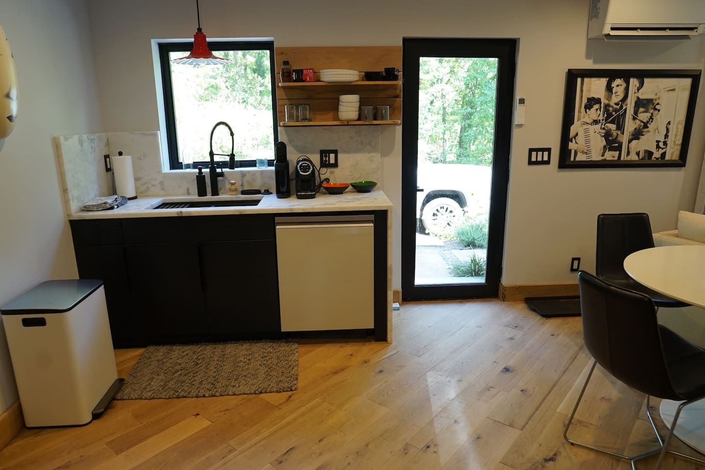 A compact kitchen with a sink, coffee maker, and a small refrigerator.