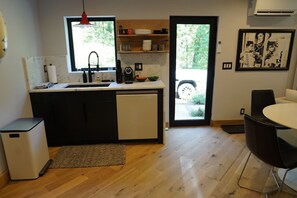 A compact kitchen with a sink, coffee maker, and a small refrigerator. - The Oakley Art House (Chattanooga)