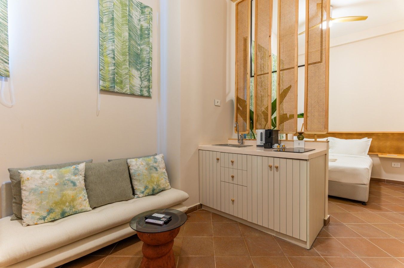 A living area with a sofa, a coffee table, a cabinet, and a bed.