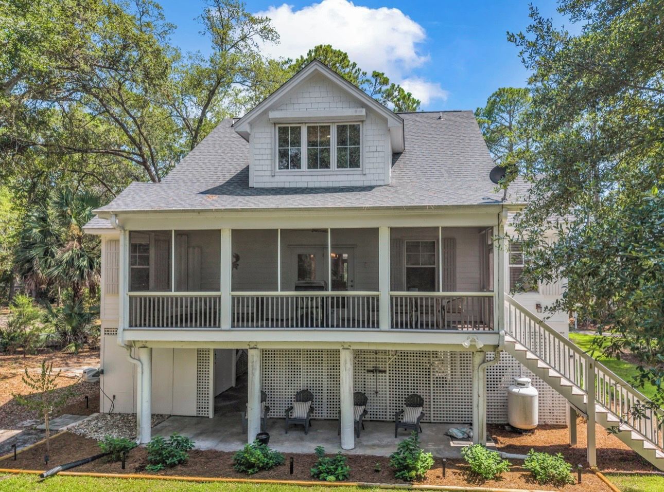 A two-story house with a balcony, a covered porch, and a staircase leading to the upper floor.