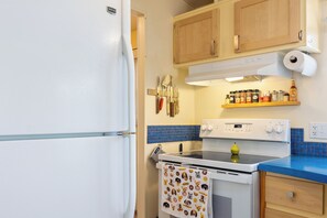 A kitchen with a white refrigerator, a stove, and a blue countertop. - Peaceful home fully fenced/gated circle driveway and ready for your stay! (Kelseyville)