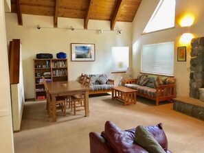 Ein gemütliches Wohnzimmer mit Holztisch, Sofa und Bücherregal.