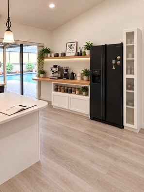A modern kitchen with a built-in island, a coffee station, and a black refrigerator. - The King’s Oasis - Private Pool & Coastal Vibe (Fort Myers)
