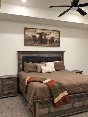 A bedroom with a bed, a headboard, a nightstand, a wall-mounted picture, and a ceiling fan. - 3-bedroom house in charming Fort Worth with AC for relaxing stays (Fort Worth)