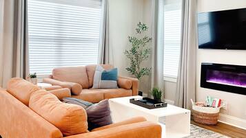 A modern living room with a sofa, coffee table, and a flat-screen TV.