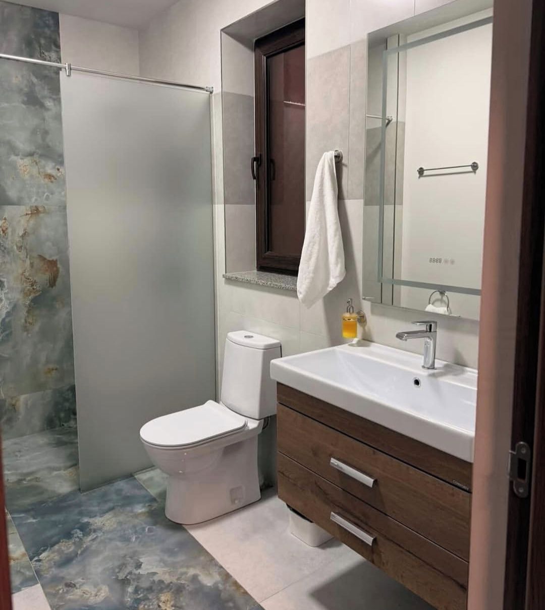 Un baño con inodoro, lavabo y espejo.
