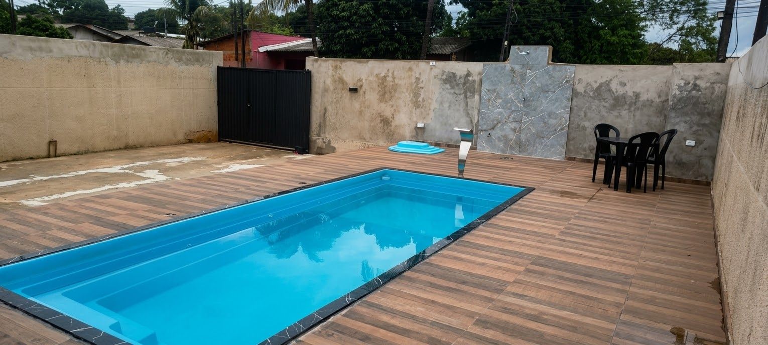Una piscina rectangular con un borde de madera que la rodea.