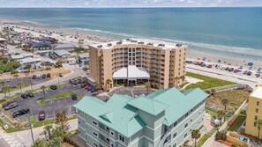 Un hôtel à plusieurs étages doté d’une cour intérieure, d’un parking et offrant une vue sur la plage.