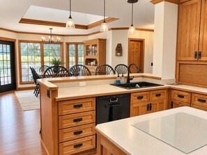 Una cocina amplia con armarios de madera, una isla central e iluminación colgante.