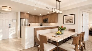 A modern kitchen with wooden cabinets, stainless steel appliances, and a central island with seating. - Marriott's Gorgeous Beachfront Waiohai Club Resort + Resort Amenities Included (Koloa)