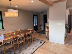 A dining area with a wooden table and chairs, a hanging light fixture, and a patterned rug. - Flatirons View Home Near Sundance Festival -  Private Main Floor, Boulder (Boulder)