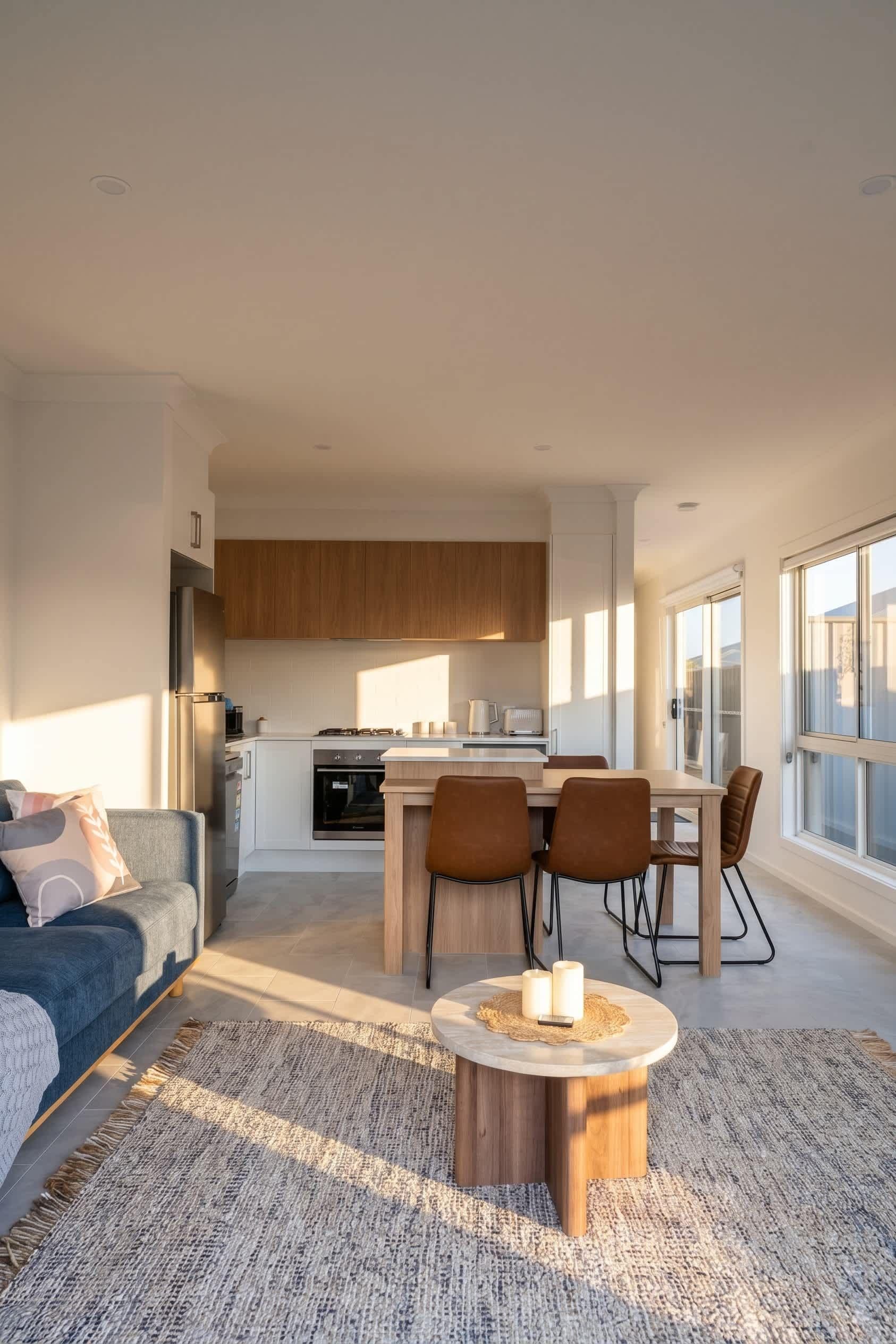 A modern living space with a kitchen, dining area, and seating.