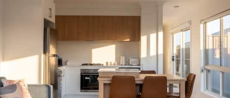 A modern living space with a kitchen, dining area, and seating.