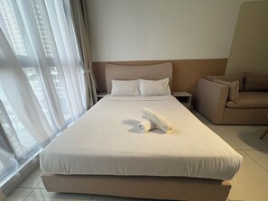 A hotel room with a large bed, a nightstand, a sofa, and a window with curtains. - Majestic Residence KLCC by Uniquehome (Kuala Lumpur)