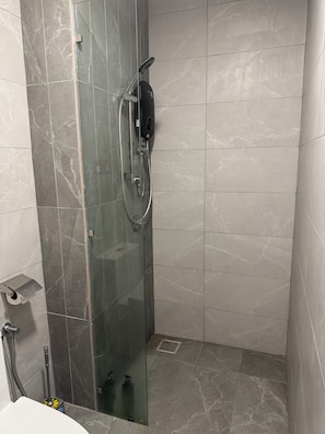 A glass-enclosed shower with a handheld showerhead and a control panel. - Majestic Residence KLCC by Uniquehome (Kuala Lumpur)