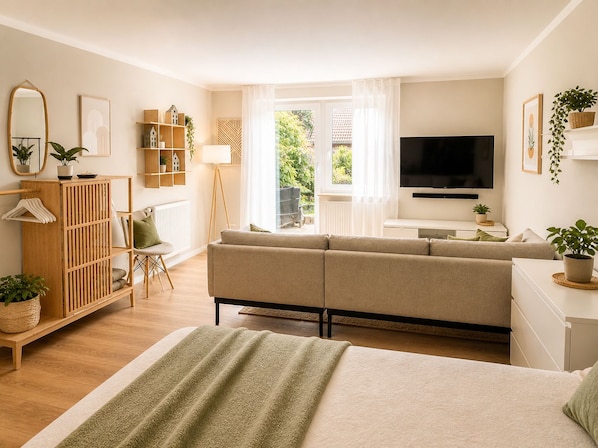 Ein modernes Wohnzimmer mit einer Couch, einem Fernseher und einem großen Fenster.