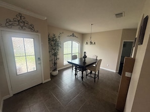 A dining area with a table and chairs, a potted plant, and a decorative wall piece. - Awesome 3-bedroom house with AC in quaint Denham Springs (Denham Springs)