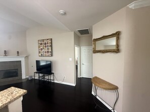 A living room with a fireplace, a television, a framed picture, and a mirror. - Awesome 3-bedroom house with AC in quaint Denham Springs (Denham Springs)