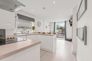 Une cuisine moderne dotée d’un îlot central, d’un coin repas et offrant une vue sur l’extérieur.