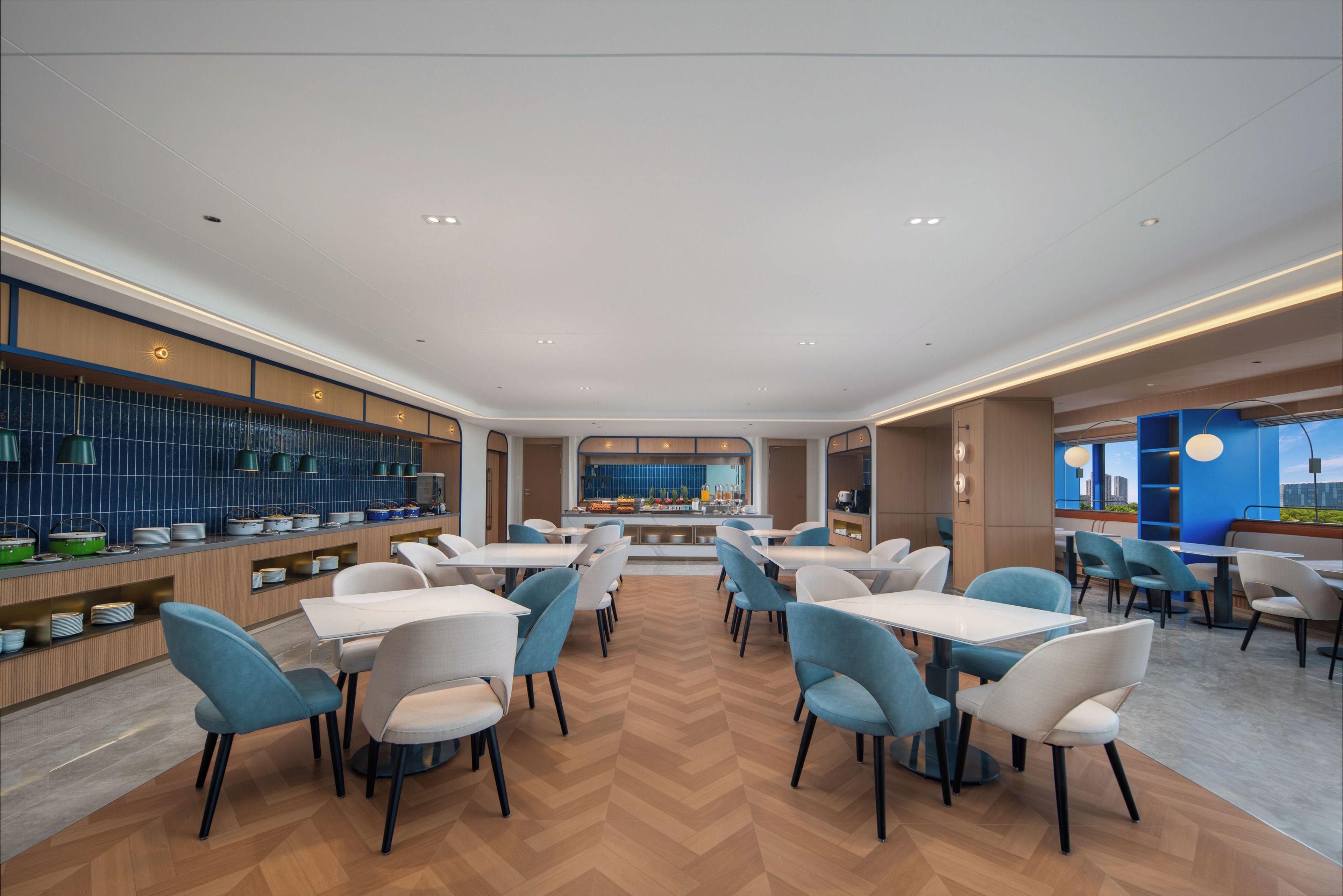 Een modern restaurant met een centrale bar, diverse zithoeken en uitzicht over de stad.