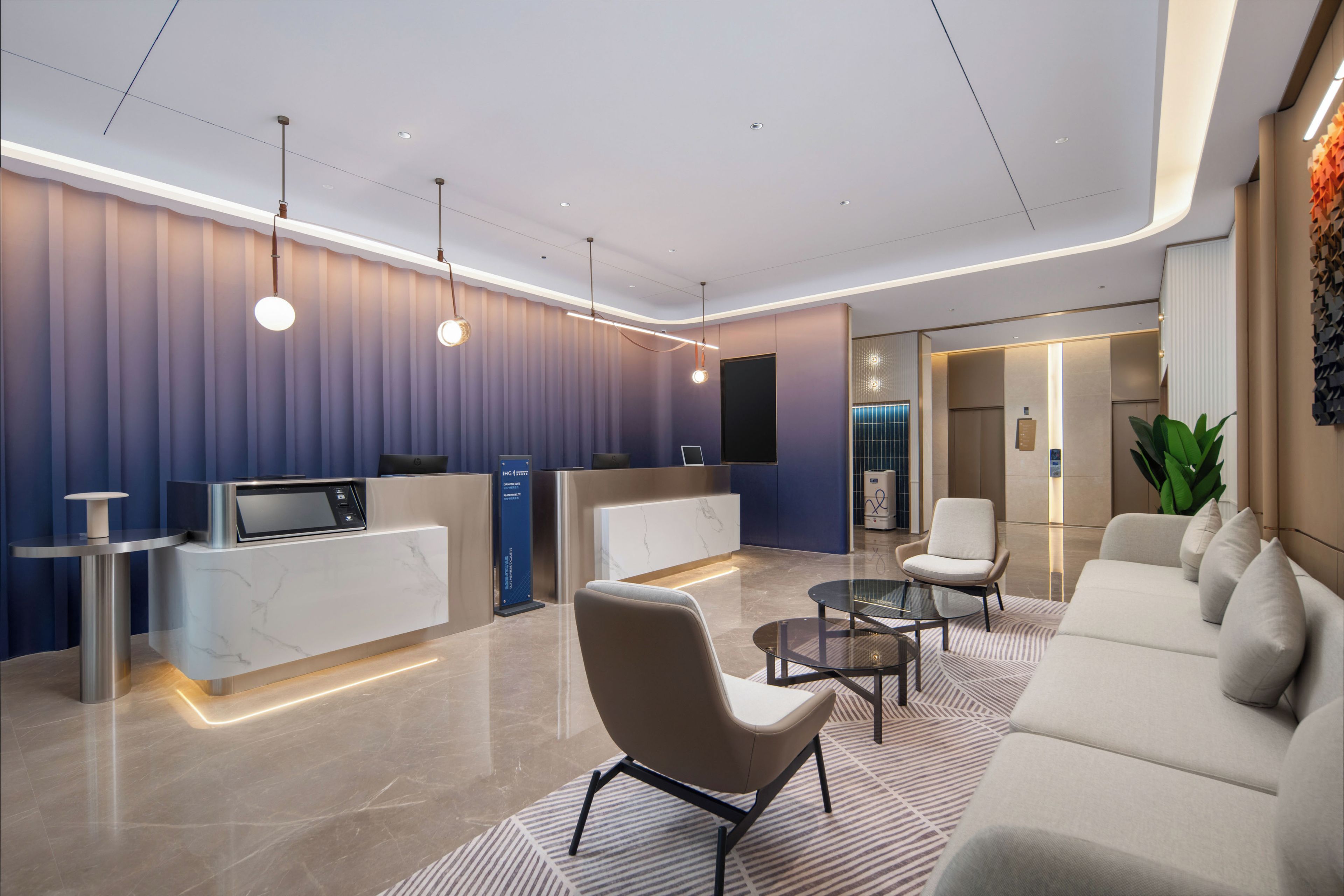 A modern reception area with a marble counter, seating, and a flat-screen TV.