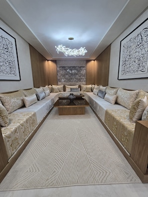 A modern living room with a sectional sofa, a coffee table, and decorative wall art. - ✨ Luxury Apartment in Tangier – Comfort and Elegance (Tanger)