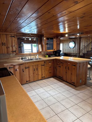 Una cocina con armarios de madera, un lavamanos y una estación de café.