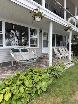 A porch with a hanging chair, a small garden, and a sign that reads 'Lake'. - Lakefront Maine Getaway - Private Dock & Kayaks (Burnham)
