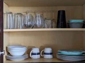 Un armario de cocina con cristalería y vajilla.