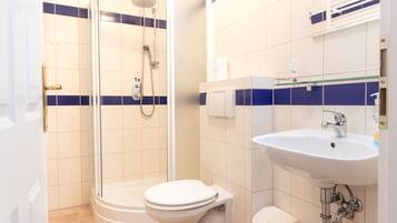 A bathroom with a shower, toilet, and sink.