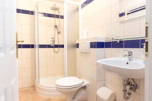 A bathroom with a shower, toilet, and sink. - Hamr Apartmány (Nové Hamry)
