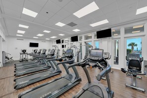 Academia com esteiras, bicicletas ergométricas e equipamentos de cardio.