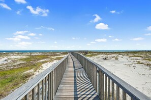 A wooden boardwalk leading to a beach with a clear sky. - Gulf Coast Beach Oasis Getaway (Gulf Shores)