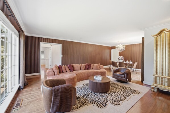 Een moderne woonkamer met een hoekbank, een ronde salontafel en een lederen fauteuil.