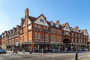 A multi-story brick building with a central entrance and a covered walkway. - Smart Artistic 1-bedroom studio in Shoreditch London with stunning city views (London)