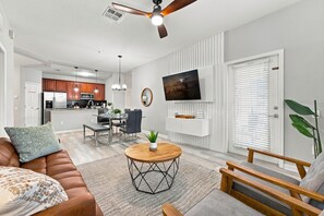A modern living room with a sofa, coffee table, and a TV mounted on the wall. - 3BR at Vista Cay, Where Comfort Meets Convenience (Orlando)
