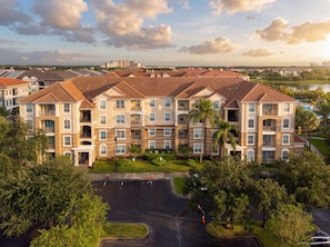 A multi-story residential building with a central courtyard, surrounded by greenery and a body of water. - 3BR Vista Cay, Conventions, Parks and Orlando Fun (Orlando)