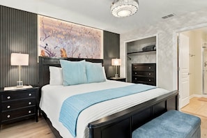A bedroom with a large bed, bedside tables, a nightstand, a dresser, a hanging light fixture, and a wall-mounted shelf. - 6BR Near Disney, Pool, Games and Themed Rooms (Kissimmee)