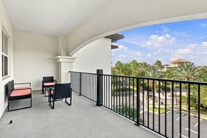 A balcony with a view of a parking area and palm trees. - Spacious 3BR Condo, Perfect Orlando Home Base (Orlando)