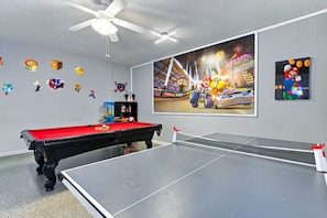 A room with a pool table, a ping pong table, and a large wall mural. - Chic 6br, Pool, Themed Rooms, Near Disney (Kissimmee)