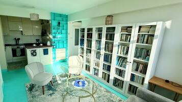 Ein Wohnzimmer mit einer Couch, einem Couchtisch und einem Bücherregal voller Bücher.