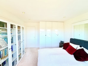 Une chambre à coucher avec un lit, une armoire et une bibliothèque.