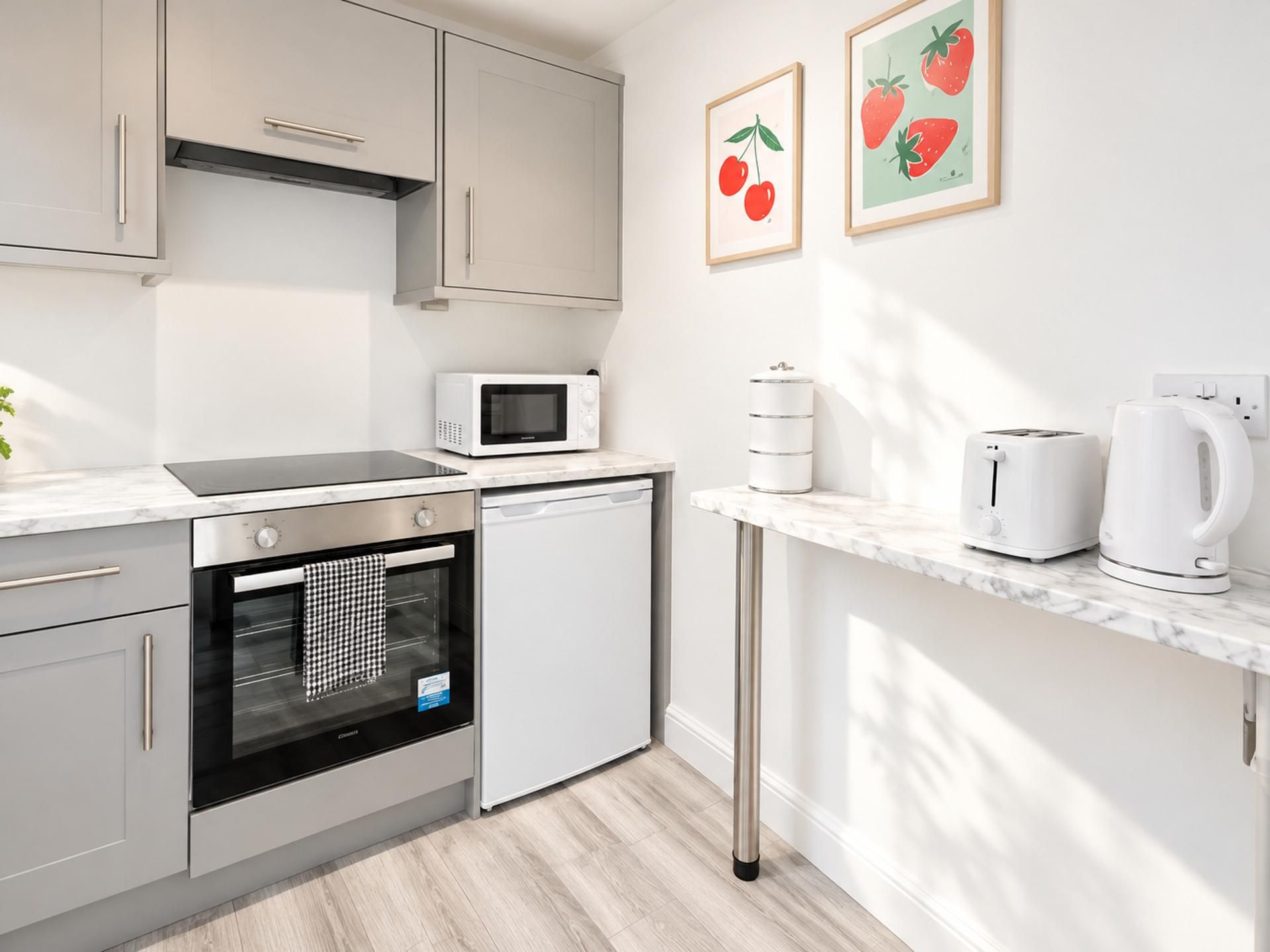 Eine moderne Küche mit Edelstahlgeräten, einer Mikrowelle, einem Toaster und einer Kaffeemaschine auf der Arbeitsfläche.