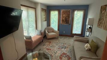 A living room with a sofa, armchair, and a coffee table with a decorative item.