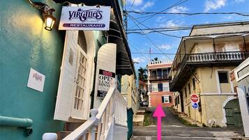 Une vue de rue avec une enseigne de restaurant, un escalier et un panneau indiquant « Entrée interdite ».