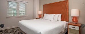 A hotel room with a large bed, two bedside tables with lamps, a window with blinds, and a carpeted floor. - Resort 1 bedroom in Anaheim for National Association of Music Merchants - NAMN (Anaheim)