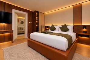 Ein modernes Schlafzimmer mit einem großen Bett, Holzvertäfelung, einem Flachbildfernseher und einem begehbaren Kleiderschrank.