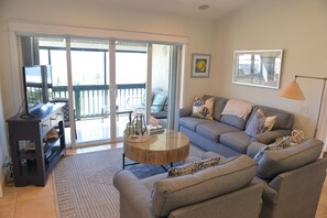 A living room with a sofa set, a coffee table, and a television on a stand. - Luxury Island Escape 3BR, Panoramic Views, AC, Pool, Free Concierge, & Generator (St Thomas)