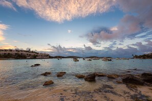 A coastal scene with boats, rocky shoreline, and buildings in the background. - Luxury Island Escape 3BR, Panoramic Views, AC, Pool, Free Concierge, & Generator (St Thomas)