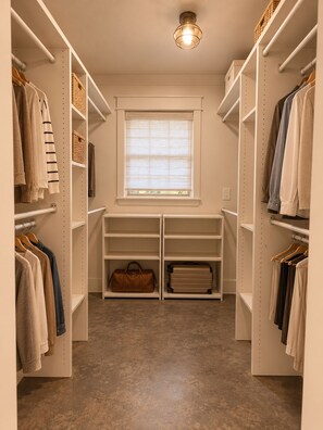 A walk-in closet with open shelving, a window with blinds, and a light fixture. - The Guesthaus- A Cozy Wooded Retreat in Murfreesboro (Murfreesboro)